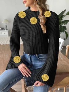 Women's black chunky knit crop sweater with yellow crochet flowers and flared sleeves