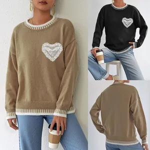 Detail of knit sweater showing heart lace applique and striped ribbed crewneck cuffs