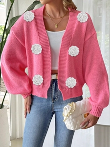 Detail of hot pink cardigan featuring 3D white crochet roses and ribbed lantern sleeves