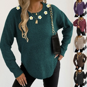 Dettaglio del maglione a girocollo con applicazioni di margherite bianche e maglia