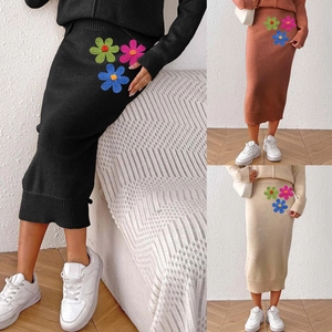 Detail of elegant knit midi skirt featuring colorful floral embroidery in three colors
