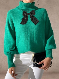 Women's green high neck sweater with a large black bow and rib-knit finish detail