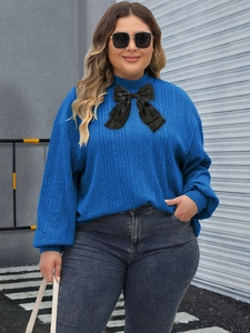 Blue rib-knit plus size sweater with high neck and large black velvet bow detail