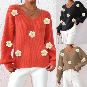 Detail showing hand-knitted 3D daisy flowers on V-neck long-sleeve knit sweaters