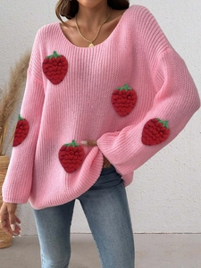 Close-up of pink chunky knit sweater with 3D red strawberry patches and green leaves