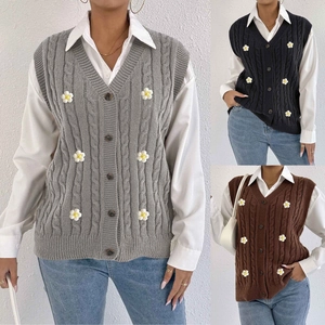 Close-up of cable knit vest with 3D white daisy floral details and V-neck button design