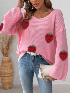 Detail of 3D strawberry embroidery patches on a pink chunky knit off-shoulder sweater