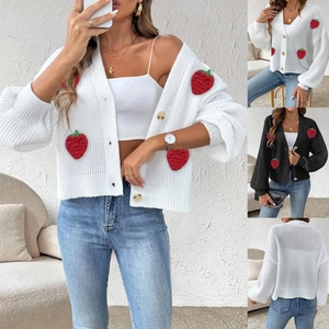 Dettaglio delle applicazioni fragola 3D e trama a maglia su un morbido cardigan da donna