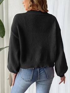 Detailed view of black chunky knit sweater texture and ribbed cuffs on the back