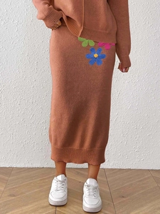 Elegant two-piece caramel knit sweater set featuring midi skirt with floral embroidery