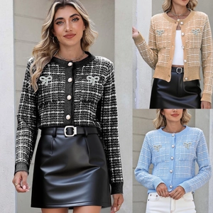 Detailansicht der Strickjacke mit Karomuster, Perlenknöpfen und glänzenden Schleifen