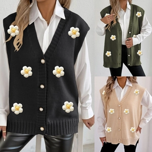 Detail view of V-neck knit vests with pearl buttons and 3D daisy flowers in three colors