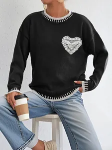 Detail of black knit sweater with white heart lace applique and contrast stitch trim