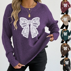 Detailed view of the intricate lace butterfly embroidery on a knitted purple sweater