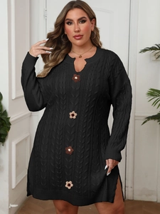 Detail showing black cable-knit dress texture with knitted flower decorations and side slits