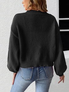 Detail of black chunky knit sweater featuring lace bow back design and ribbed cuffs