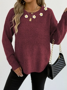 Dettaglio di un maglione bordeaux con applicazioni di fiori all'uncinetto sul collo