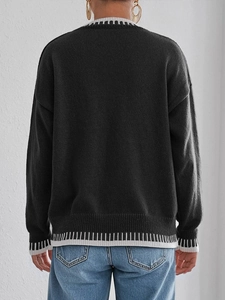 Loose black knit sweater with heart lace pockets and striped trim, rear view