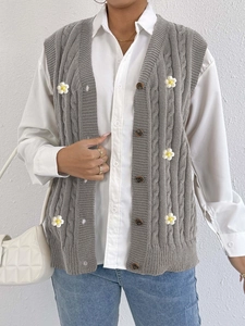 Detail of grey cable-knit cardigan vest with 3D white daisy floral appliques for women