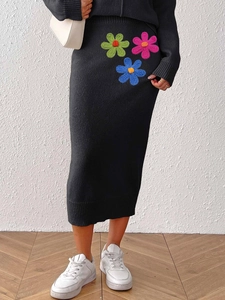 Elegant two-piece black knit set with colorful crochet flower embroidery on a midi skirt