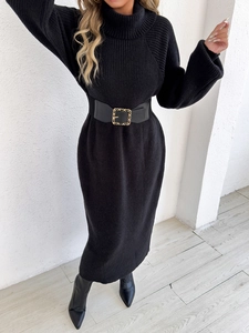 Detail of black turtleneck knit dress featuring thick ribbed texture and golden chain belt