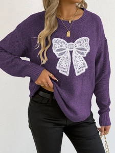 Detailed view of the dark purple knit sweater with a large white lace butterfly motif