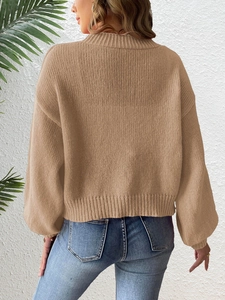 Detail of camel chunky knit cardigan featuring drop shoulder design and textured fabric