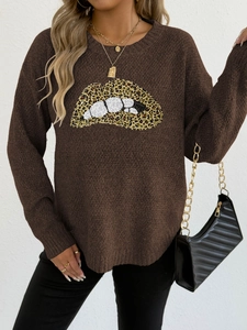Detail eines Lippen-Prints mit Leopardenmuster auf dunkelbraunem Langarmpullover
