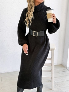 Close-up of black turtleneck knit dress with rib-knit texture and gold chain belt buckle