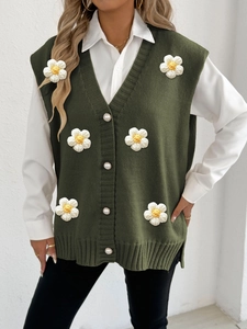 Detailed close-up of green knit vest with 3D flower petals and white pearl buttons