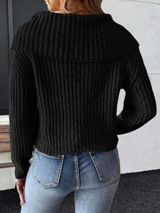 Back view of a chunky black knit sweater with a large collar and textured weave pattern
