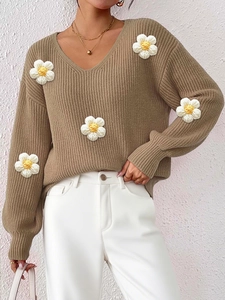 Detail of 3D crochet floral patches on v-neck knit sweater with vertical texture