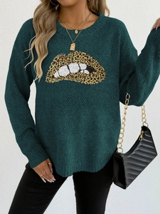 Detailaufnahme der Paillettenstickerei mit Leopardenlippen auf grünem Strickpullover