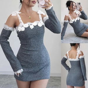 Détails d'une robe grise en maille avec bordures en dentelle blanche et nœuds aux épaules