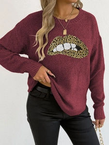 Detailansicht der Lippen-Stickerei mit Leopardenmuster auf einem weinroten Pullover
