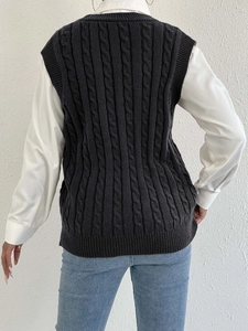 Women's knit vest featuring cable knit pattern and V-neck layered over a shirt