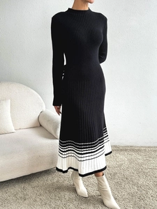 Détail d'une robe mi-longue en maille avec ourlet plissé à rayures noires et blanches