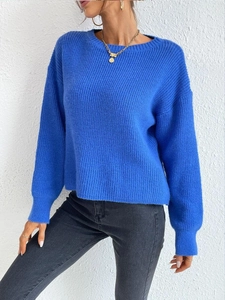 Detail of Klein blue knit sweater featuring ribbed texture and elegant crew neck design