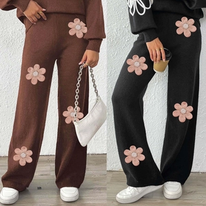 Detail of pink flower applique with pearl beads on knitted wide leg trousers