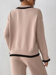 Rear view of women beige knit set featuring black contrast ribbing on sweater and pants