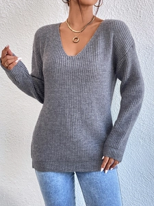 Close-up of grey V-neck knitted sweater featuring ribbed texture and stylish lace stitching