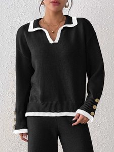Close-up of contrast knit sweater with white collar and decorative gold buttons