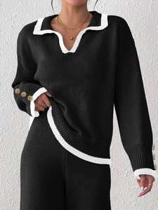 Women's black knit two-piece set with contrast white trim and gold decorative buttons