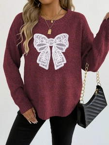 Close-up of wine red knit sweater featuring a white lace butterfly applique design
