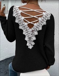 Detail of backless black knit sweater featuring white lace trim and criss-cross ties