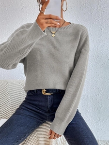 Close-up of light grey ribbed knit texture on a loose-fitting long sleeve sweater
