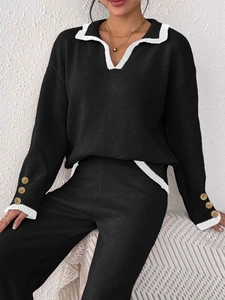 Detailed close-up of knit fabric with golden buttons and contrasting white collar trim