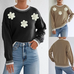 Detail view of 3D knit floral embroidery and beadwork on color block women sweater