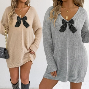 Detail of V-neck knitted sweater dress with large black bow accent in apricot and gray