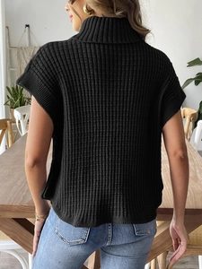 Vista dettagliata del retro di un gilet nero in maglia a collo alto con trama a righe